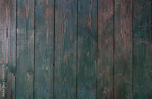 Green paint on an old wooden background. Fence.