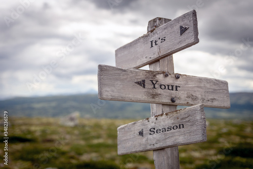 its your season text engraved on old wooden signpost outdoors in nature. Quotes, words and illustration concept.