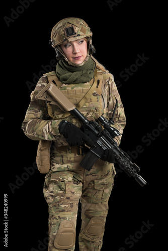 Female soldier in tactical black uniform with rifle. Shot in studio. Isolated with clipping path on black background