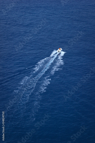 Motor boat sailing by the sea or ocean. Top view with splashes on water surface.  © Mediagfx