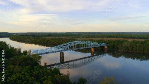 Birds fly in foreground as cars traverse the Wabash Memorial Bridge spanning White County Illinois and Posey County Indiana. Right to left camera movement. photo