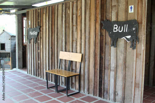Cow-shaped toilet sign, made of black painted wood. © noomcm