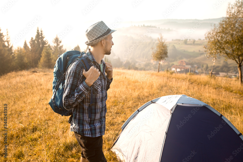 Handsome bearded man tourist exploring new places on top of mountains. Hiker man in hat with backpack happy to see sunrise Handsome bearded man tourist exploring new places on top of mountains. Hiker man in hat with backpack happy to see sunrise