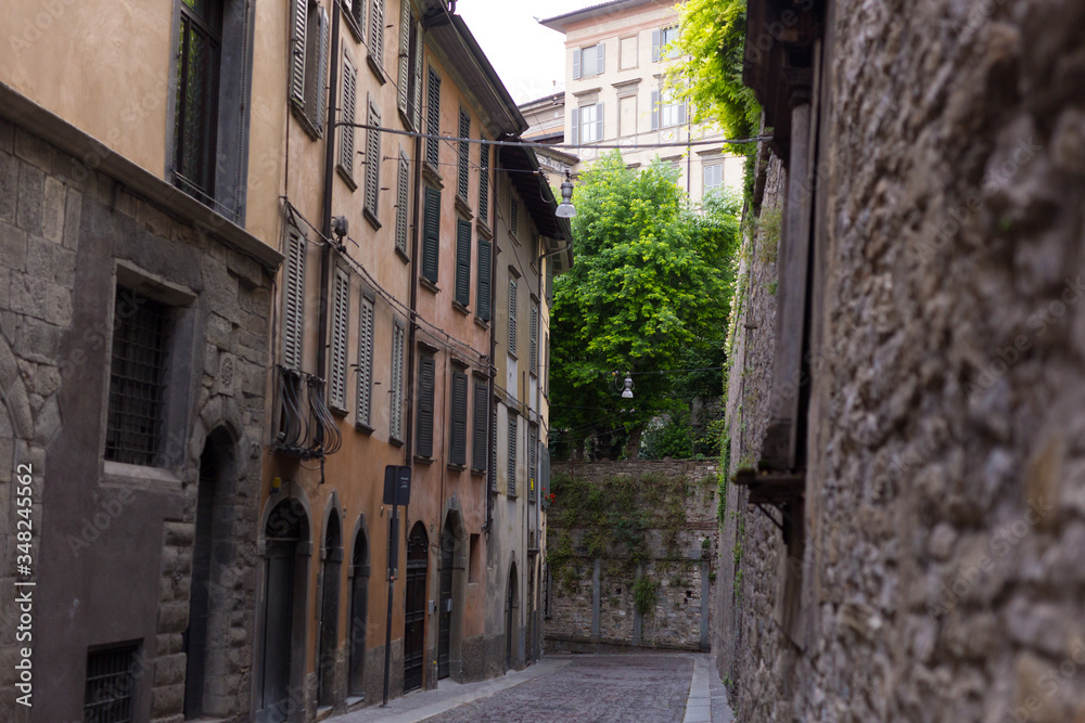 Traditional narrow Italian street and no people in Bergamo historical center, Italy. Medieval buildings. There's no one on the street.
