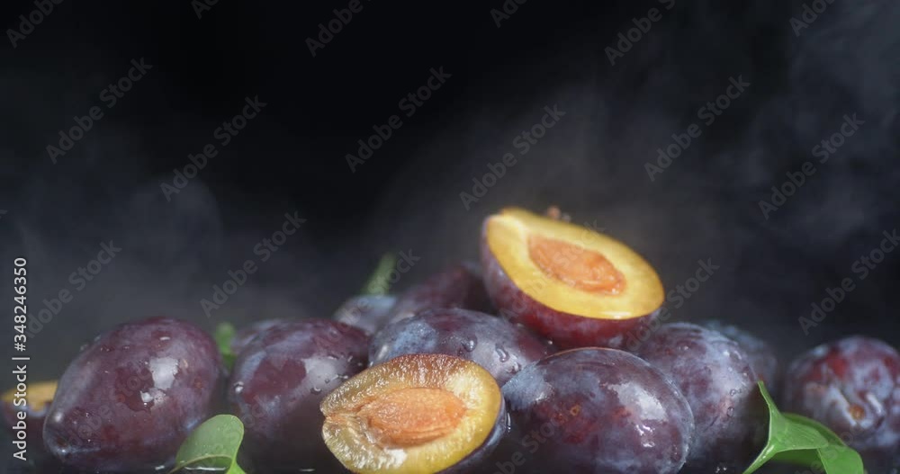 Ripe plum with leaves and cool steam.