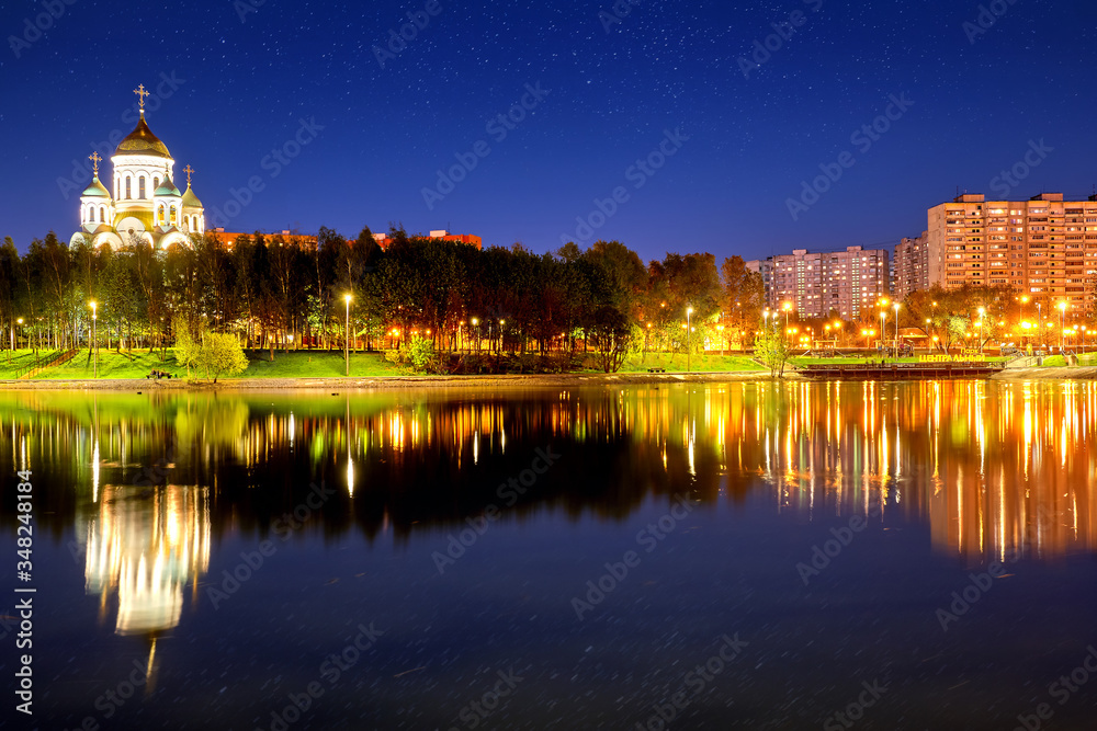 russian city skyline architecture landmark at night against starry sky background. Urban street wide view of Moscow city Russia cityscape. City park with orthodox church landscape at evening