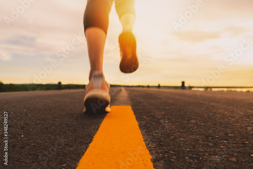 Athlete running on the road trail in sunset training for marathon and fitness. motion blur of woman exercising outdoors