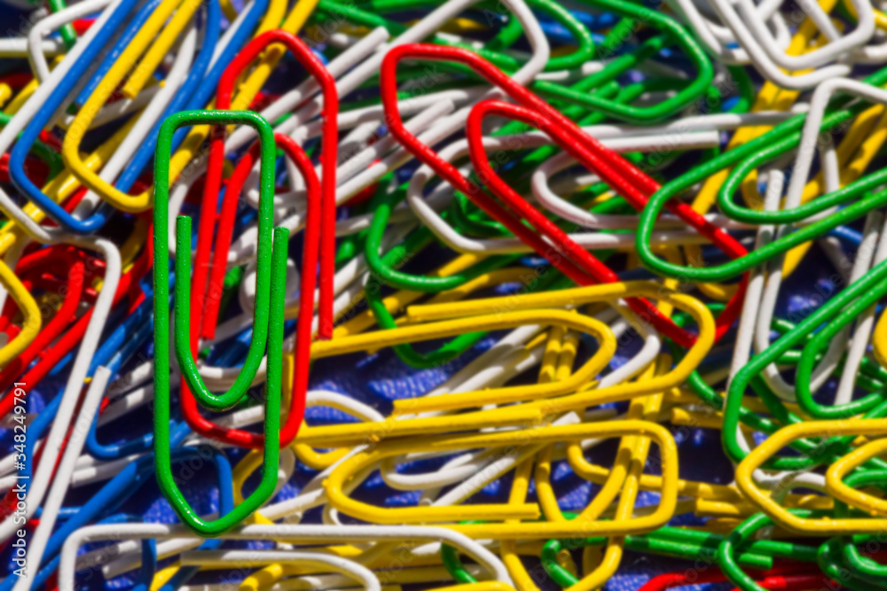 Close up one green paper clip in colorful paper clips, background Close up one green paper clip in colorful paper clips, background