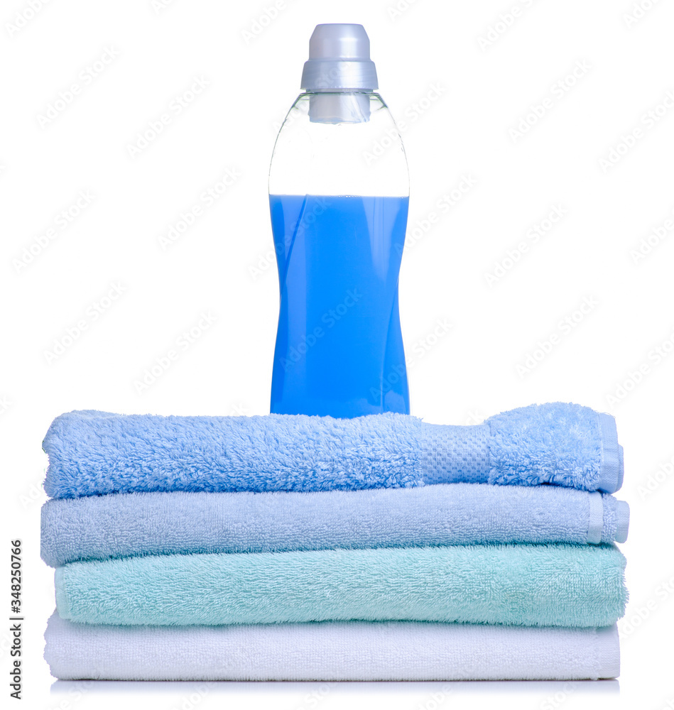 A stack of towels softener conditioner liquid laundry detergent on white background isolation A stack of towels softener conditioner liquid laundry detergent on white background isolation