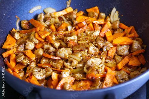 Sliced onions and carrots and pan-fried meat, background, cooking a traditional Eastern dish pilaf