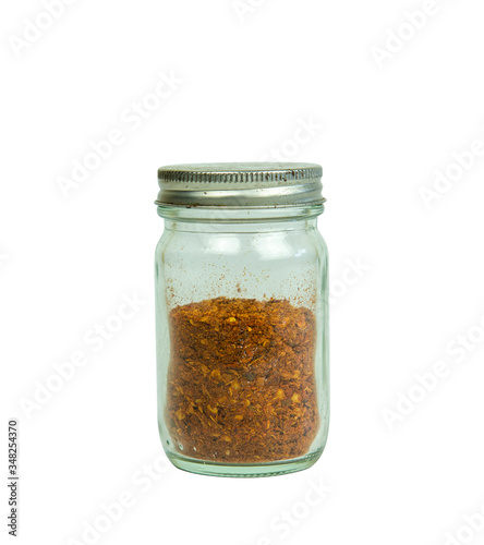 Cayenne pepper in a glass jar cover only half the bottle on white background