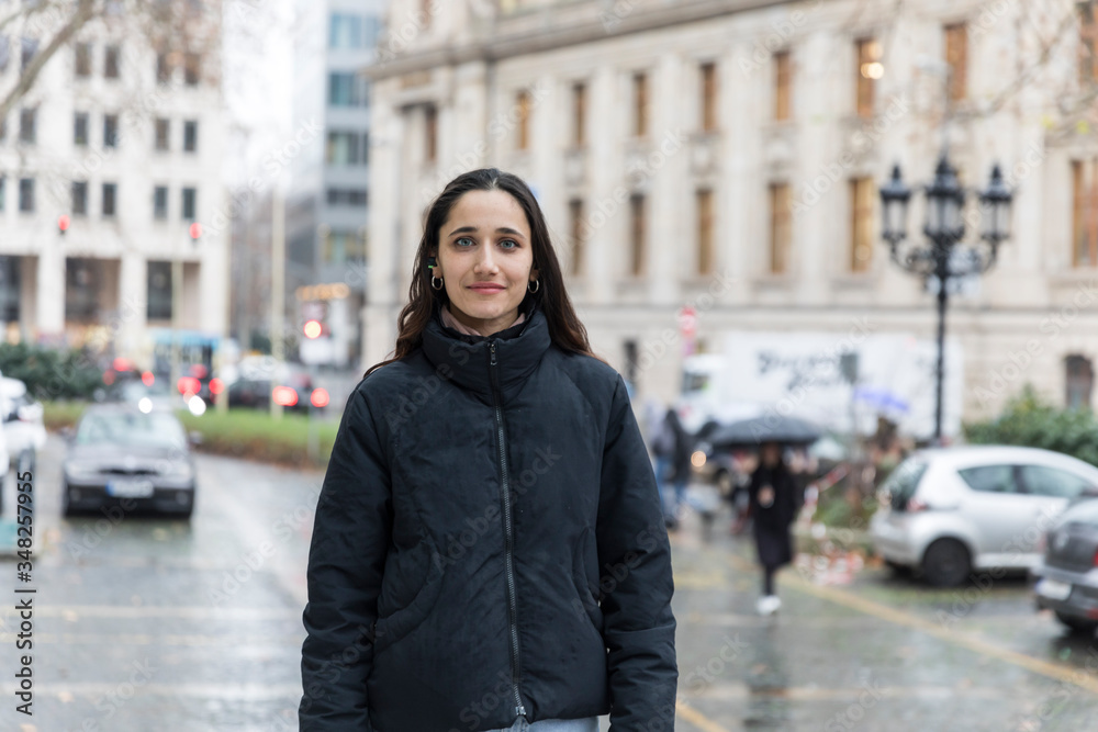 Fototapeta premium Urbanite young Indian woman posing in city looking at the camera.