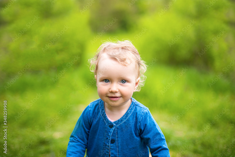 Little girl plays on nature against the background of spring greenery. Little girl plays on nature against the background of spring greenery.