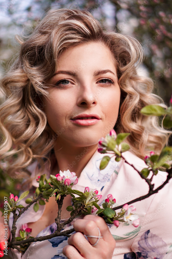 Romantic young woman in the spring garden among apple blossom. Beautiful woman, happy spring Romantic young woman in the spring garden among apple blossom. Beautiful woman, happy spring