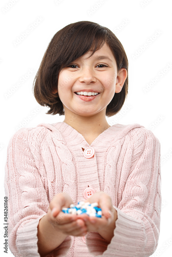 Child holds handful of pills on white background. Child holds handful of pills on white background.