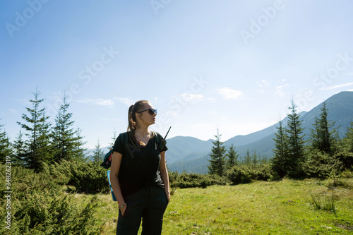 girl tourist stands with a walkie-talkie in the mountains before climbing to the mountains © Rock and Wasp