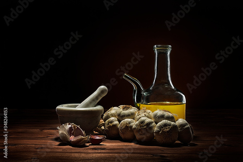 still life of garlics and glass container for olive oil