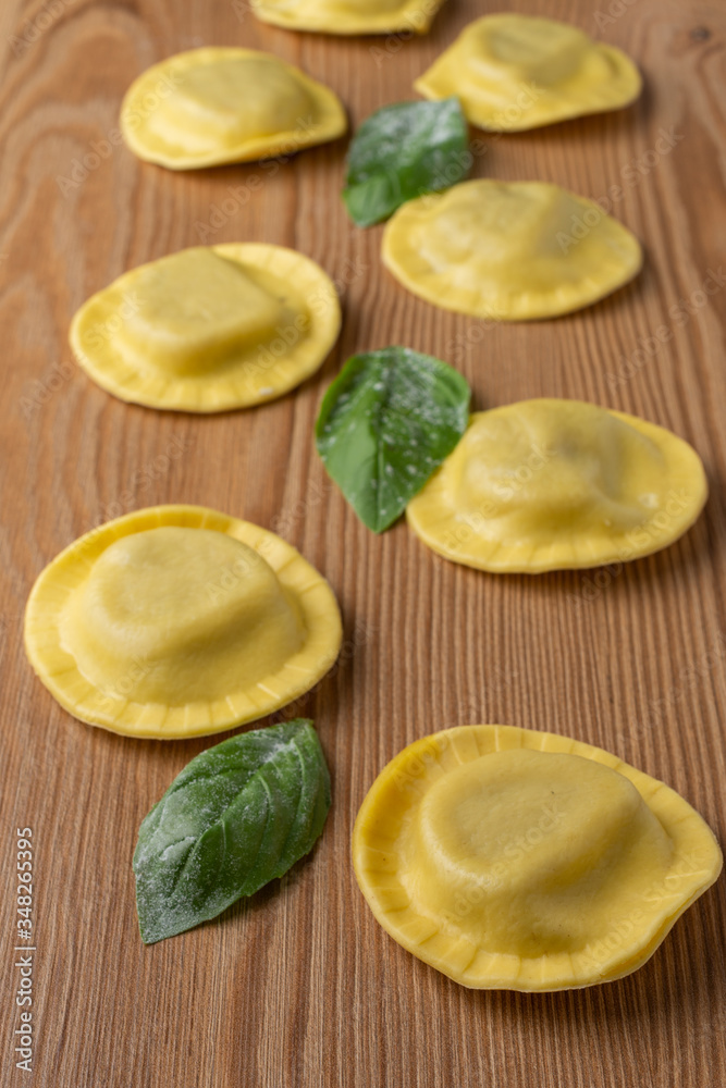 Top view of ravioli with mushrooms and basil, on wooden table, vertical Top view of ravioli with mushrooms and basil, on wooden table, vertical