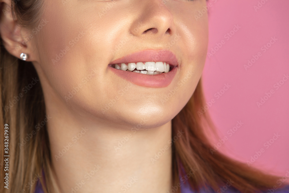 Close up of female smiling. White teeth and kept lips. Caucasian young woman's portrait on pink studio background. Beautiful model. Concept of human emotions, facial expression, sales, ad. Copyspace. Close up of female smiling. White teeth and kept lips. Caucasian young woman's portrait on pink studio background. Beautiful model. Concept of human emotions, facial expression, sales, ad. Copyspace.