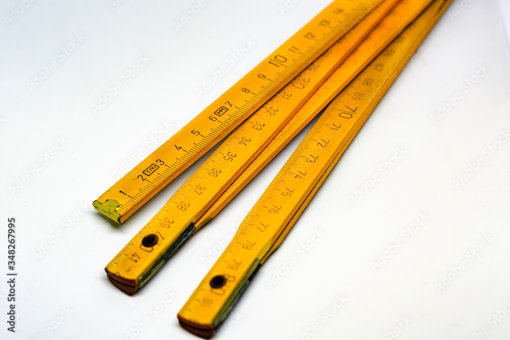 Yellow wooden folding meterstick with brass ends isolated on a white background Yellow wooden folding meterstick with brass ends isolated on a white background
