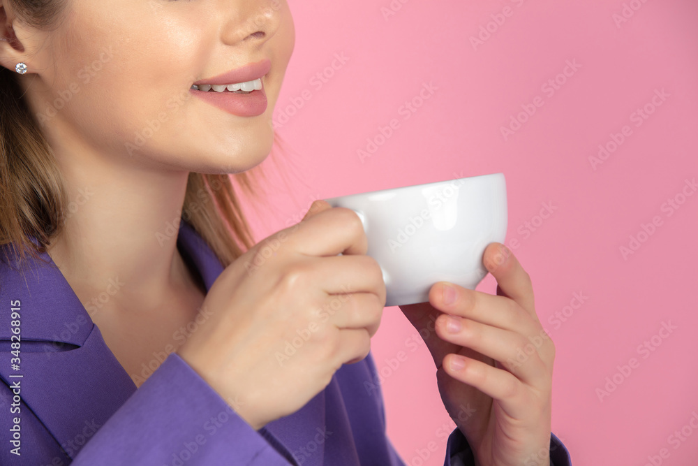 Close up of female smiling. Drinking coffee, tea. Caucasian young woman's portrait on pink studio background. Beautiful model. Concept of human emotions, facial expression, sales, ad. Copyspace. Close up of female smiling. Drinking coffee, tea. Caucasian young woman's portrait on pink studio background. Beautiful model. Concept of human emotions, facial expression, sales, ad. Copyspace.