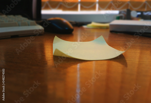 Curved empty sticky note on wooden table bokeh background photo