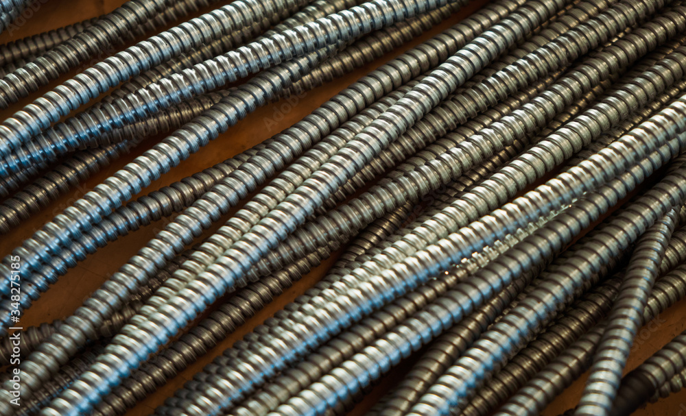 Huge bunch of metal flexible shield tubes with nuts