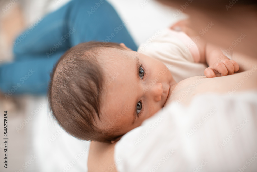 Close-up portrait of a child sucking milk from its mother's breast. Close-up portrait of a child sucking milk from its mother's breast.