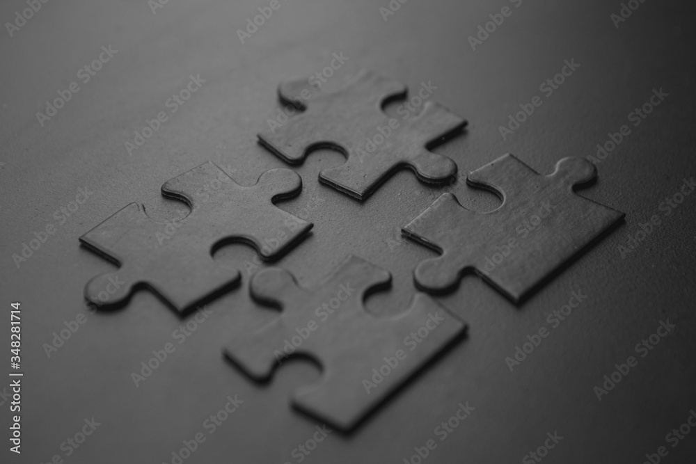four black puzzles on a dark background four black puzzles on a dark background