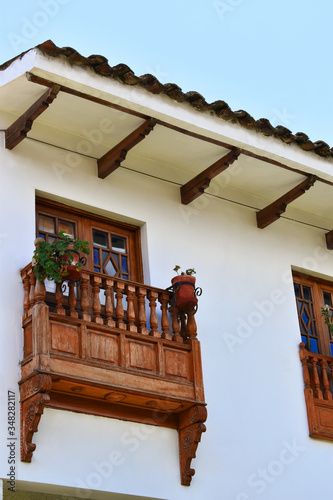 Fachada blanca con balcón de madera 