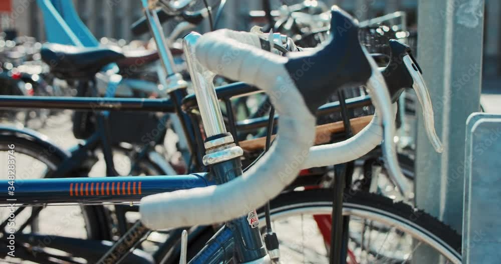 Commuter city bikes parked on city parking in cycling friendly infrastructure in european city like amsterdam or copenhagen. Bike to work social programme. Green environment initiative for commuters