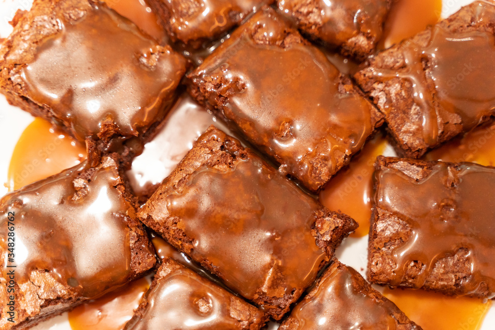 Top view on pieces of brownie poured with salted caramel sauce Top view on pieces of brownie poured with salted caramel sauce