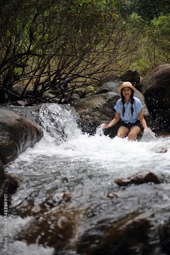Woman soaking in the Trok Nong waterfall in Chanthaburi, Thailand