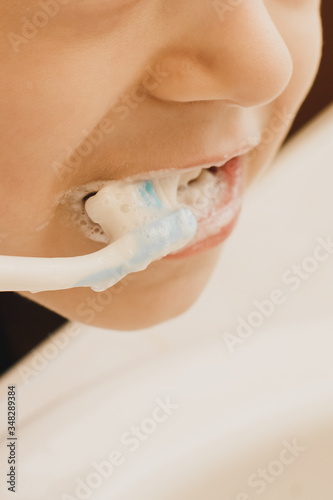  The child brushes his teeth with a toothbrush.
