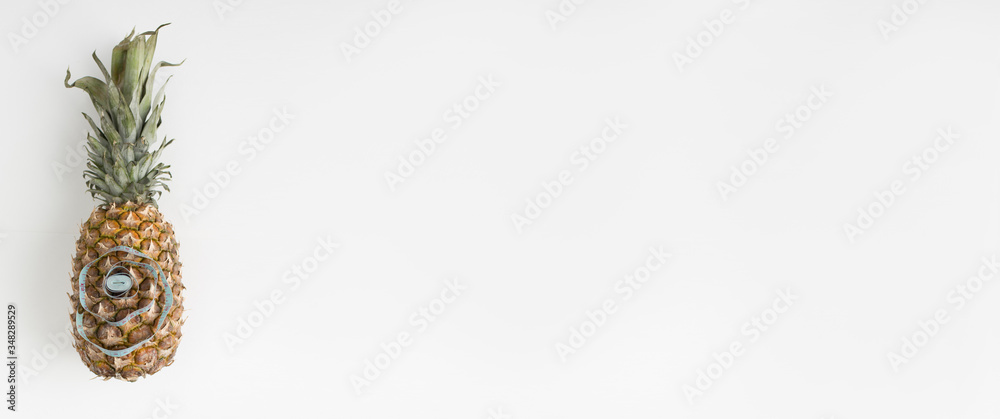 Fototapeta premium Pineapple fruit with a centimeter measuring tape. on white background. healthy food. food for weight loss.