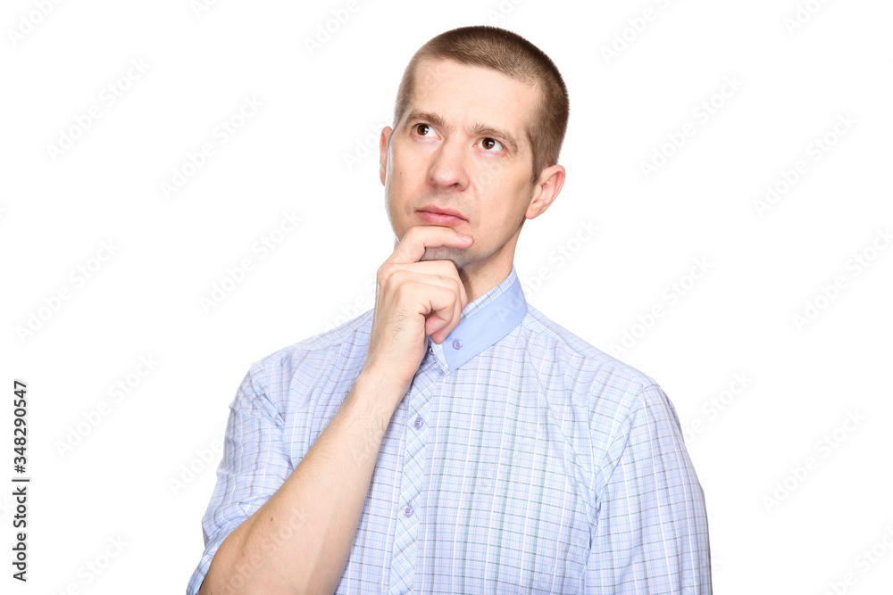 brooding dreaming man in a classic blue shirt; holds his hand at the chin in dreams and thoughts; look into the camera. Isolated brooding dreaming man in a classic blue shirt; holds his hand at the chin in dreams and thoughts; look into the camera. Isolated