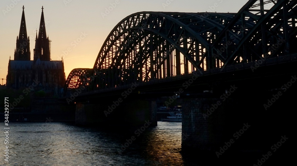 Naklejka premium Kölner Dom und Hohenzollernbrücke im Sonnenuntergang am Abend