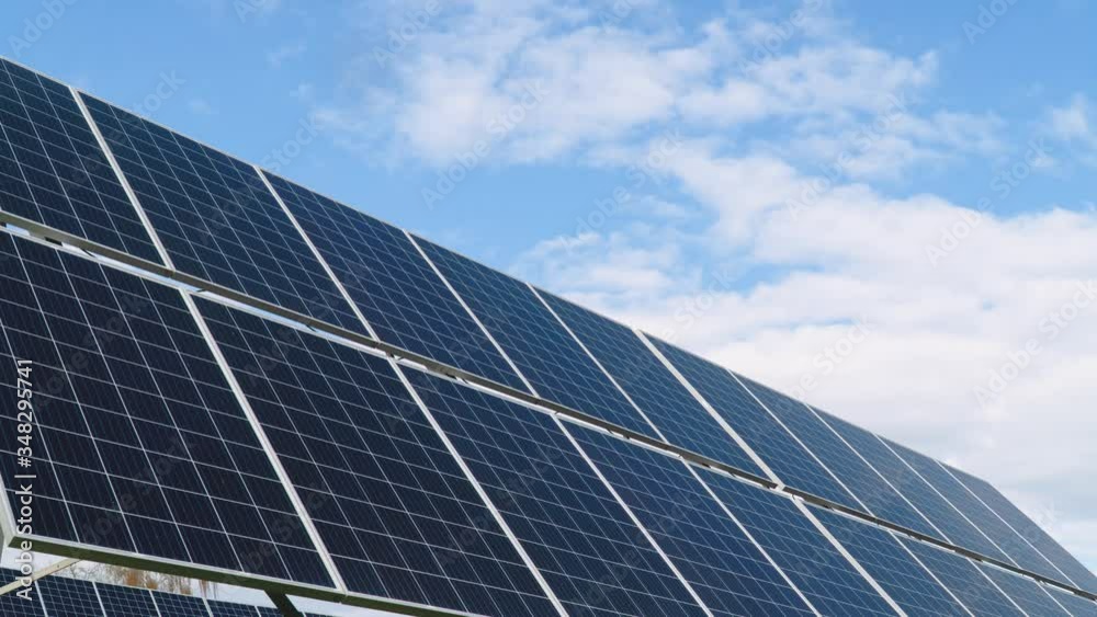Solar panels on the blue sky background. Concept of green energy, clean energy, renewable energy. Time lapse