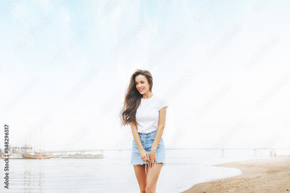 Young beautiful happy woman walks on beach in marina Young beautiful happy woman walks on beach in marina