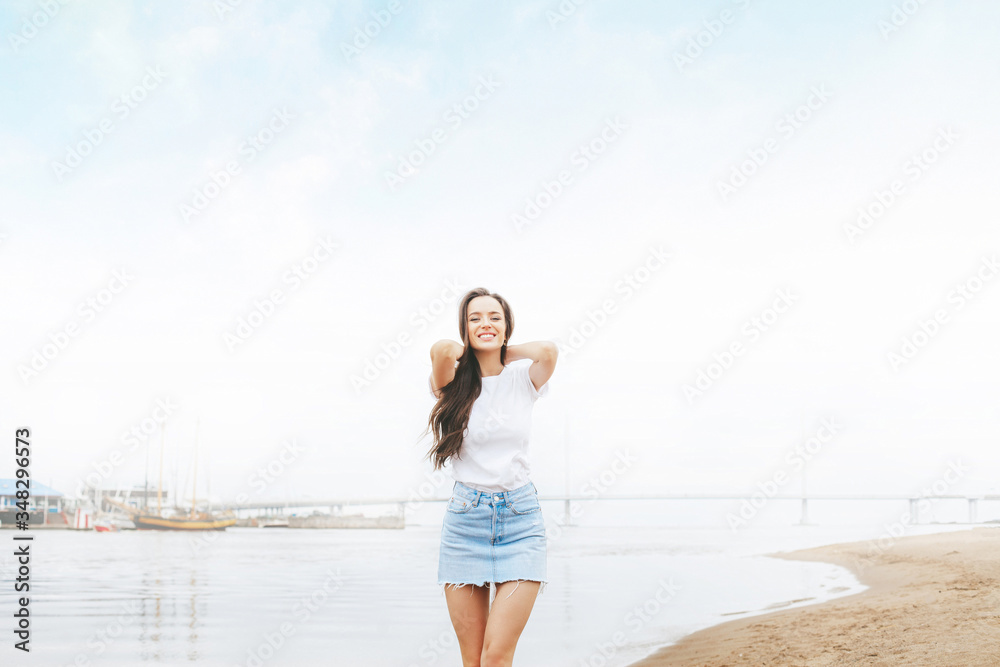 Young beautiful happy woman walks on beach in marina Young beautiful happy woman walks on beach in marina