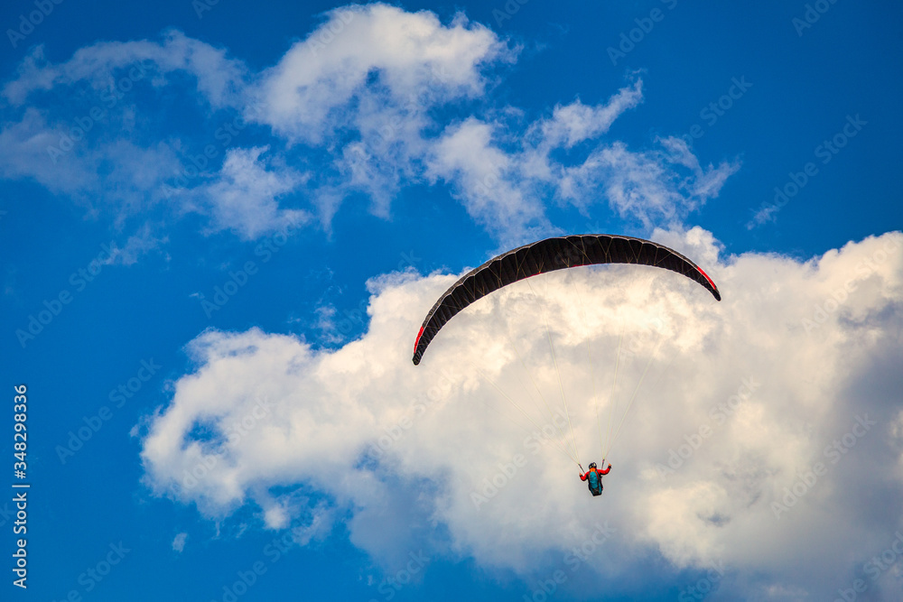 Flying paraglider on a background of blue sky with clouds. Flying paraglider on a background of blue sky with clouds.