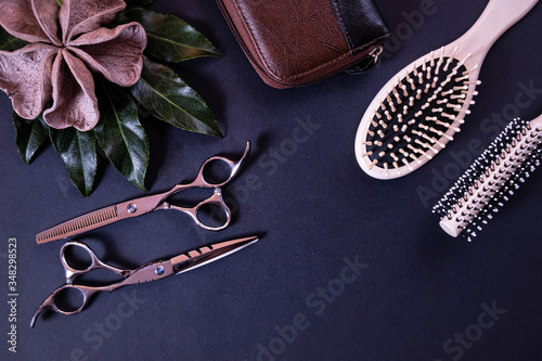 a leather bag for scissors, scissors for a hairdresser and comb lie on a textured background