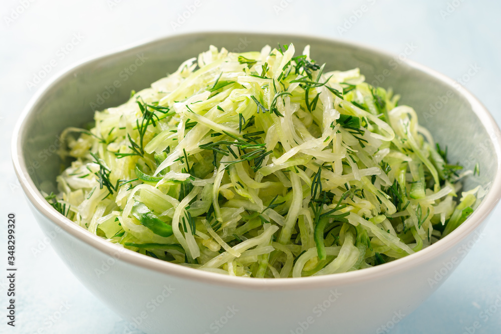 Fresh cabbage and cucumber salad with dill in bowl on concrete background. Coleslaw. Fresh cabbage and cucumber salad with dill in bowl on concrete background. Coleslaw.