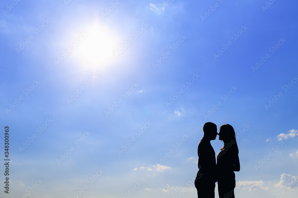 guy and girl silhouettes on blue sky background. sunny day. prof