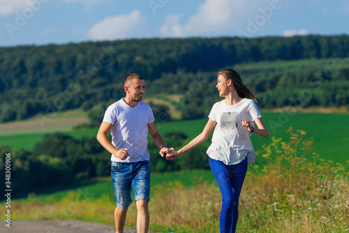 girl and guy holding hands and running against the background of