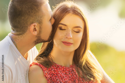 girl with beautiful makeup closed her eyes and the guy kisses he
