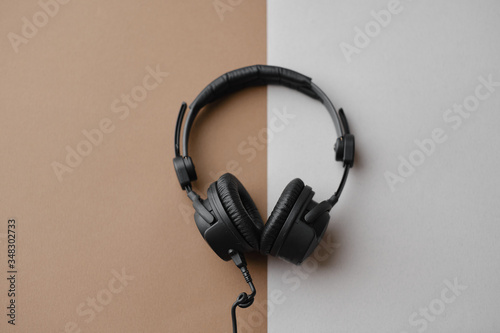 Flat lay composition with black studio headphones  on brown background, podcasting concept. photo