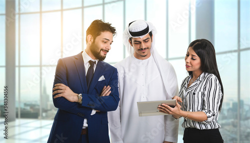 Group of businesspeople using a digital tablet together inside office Standing front the window.
