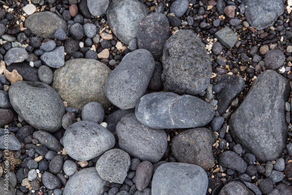 Gray pebbles stones on the shore close up view from above Gray pebbles stones on the shore close up view from above