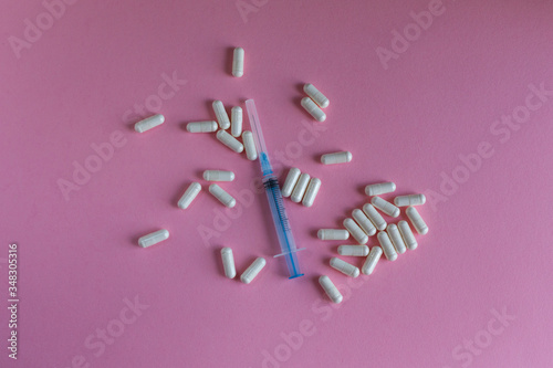 syringe pills vaccina coronavirus pink background photo